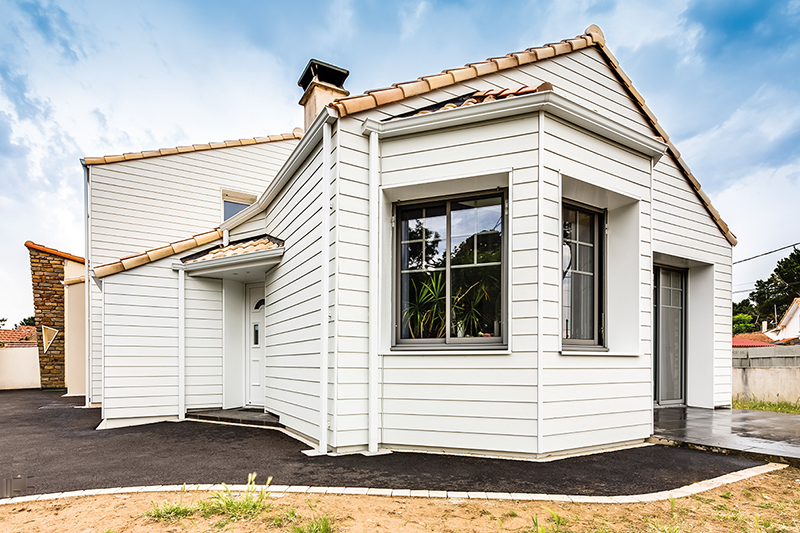 Maison de couleur blanche dont le revêtement est fait de panneaux Hardie® Plank